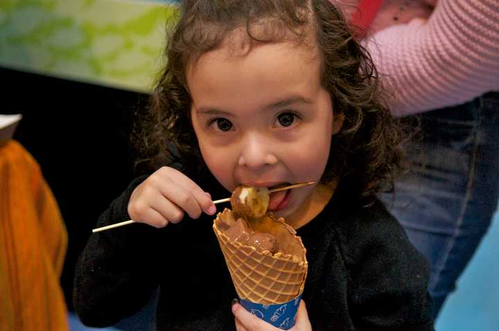 A young girl enjoys a chocolate treat at the Chocolate Expo at the Maritime Aquarium at Norwalk on Sunday.