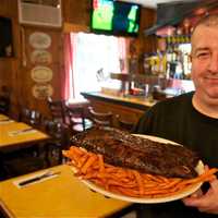 <p>Holy Smoke owner Chris Casino shows off a rack of his popular ribs.</p>