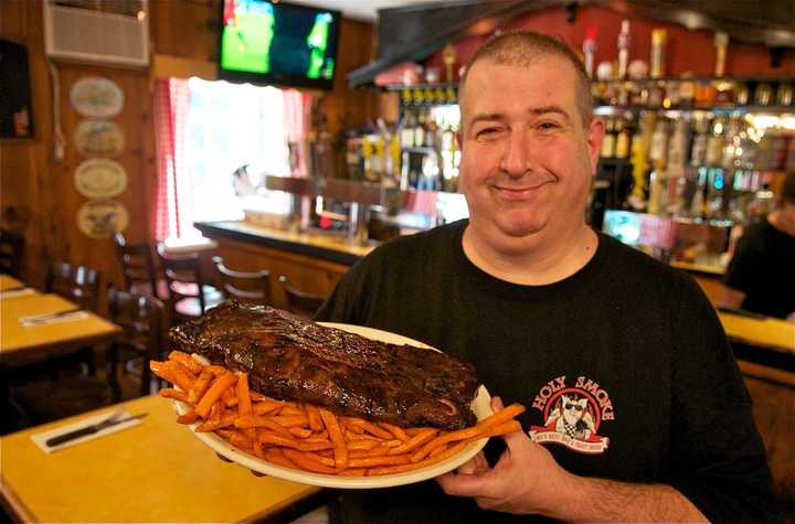 Holy Smoke owner Chris Casino shows off a rack of his popular ribs.