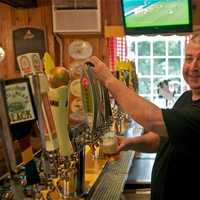 <p>Holy Smoke owner Chris Casino draws one of many craft beers on tap.</p>