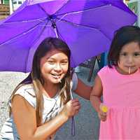 <p>These girls try to stay cool with an umbrella at Saturday&#x27;s farmers market in Ossining.</p>