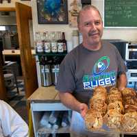 <p>Hungry? Owner Mark Jayson tempts customers with a tray of his muffins.</p>