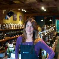 <p>Blue Olive co-owner Beth Canevari with her olive oil and vinegar products.</p>