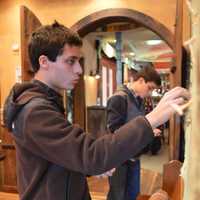 <p>The Yammerino twins affixing plastic spiders to Halloween decorations by the entrance of the Blue Moon Mexican Cafe in Norwood.</p>