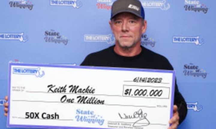 Keith Mackie holds his winning $1 million prize