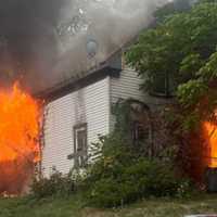 <p>Flames shooting from the building at 34 Maple Street in Fitchburg</p>