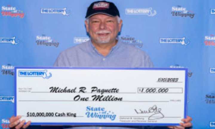 Michael Paquette holding his $1million lottery prize