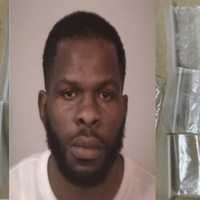 <p>Adwain Sharrier (center) with recovered bags of an suspected substance recovered from his car</p>