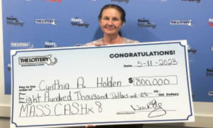 Cynthia Holden stands with her winning check for $800,000