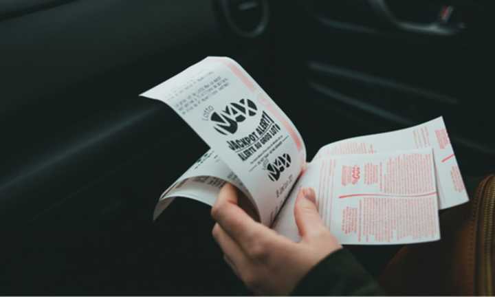 A hand holding multiple lottery tickets.