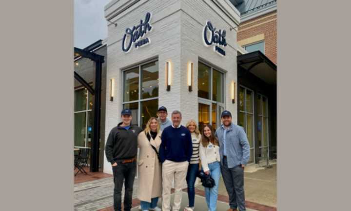 Bill Ebben, the owner of the new franchise location, stands in front of the restaurant with his family.