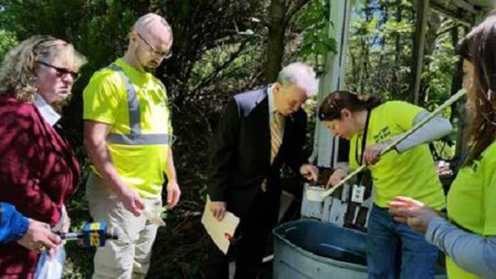 Rockland County Executive Ed Day, center, and others examine potential breeding places for mosquitoes while touring an abandoned home in Chestnut Ridge recently.