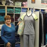 <p>Diane Some with a scrub uniform from her huge inventory of comfortable, wearable work clothes.</p>