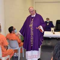 <p>Cardinal Dolan with prisoners.</p>