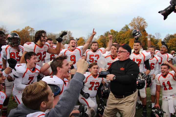 Hasbrouck Heights head coach Nick Delcalzo shares the inaugural NJIC Championship trophy with his team.