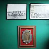 <p>Dylan looks over his great grandfather&#x27;s high school accomplishments, including newspaper clipping and his Hall of Fame induction plaque.</p>