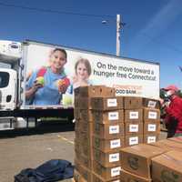 <p>A volunteer moves boxes of food during the event.</p>