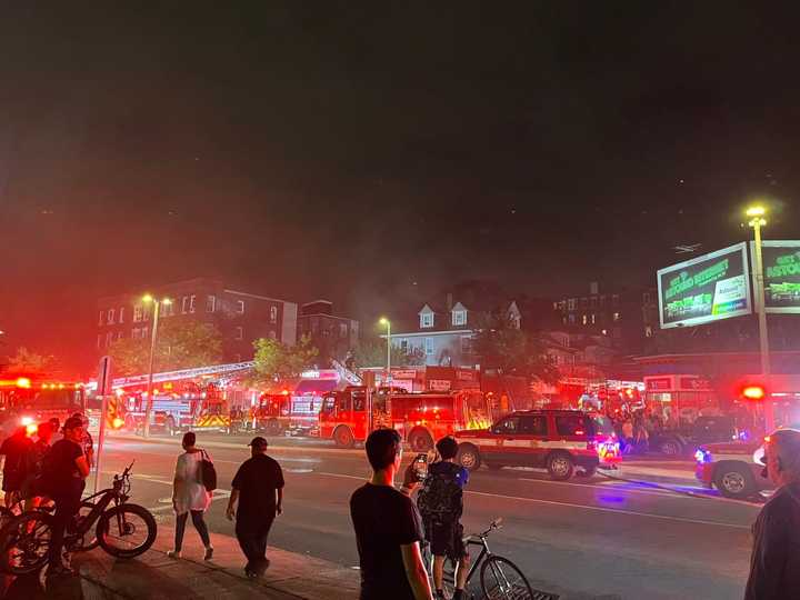 Residents watch as Boston firefighters respond to a fire in Allston Tuesday night