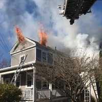 <p>Smoke and flames coming from a home on Union Street in Natick</p>