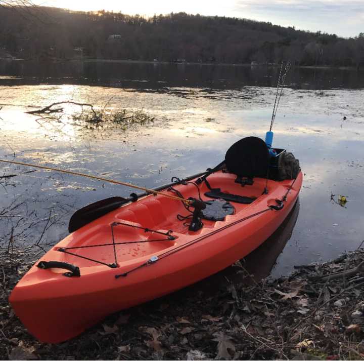 The 10-foot Emotion kayak has a hand-painted ruler on the left side and fishing rod holders both in front of and behind the seat.