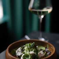 <p>A salad available at Folio is made with charred onion, chevre, peas, basil, and summer greens.</p>