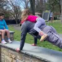 <p>Fox Lane High School Director of Health, PE &amp; Athletics Adam Lodewick does pushups with his daughter on his back for the #FoxesUp4Hero challenge to raise funds for Northern Westchester Hospital.</p>