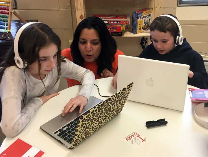 Reebel owner Reena Chawla works with two of her students during a 90-minute technology class.