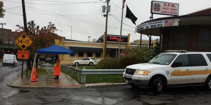 Saddle Brook police brave the rain to monitor a detour at the intersection of Saddle River Road and Market Street during PSE&amp;G construction. The township is in the process of applying for a PSE&amp;G grant.