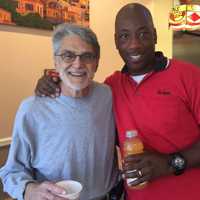 <p>Greg Pappas takes a break from the kitchen to pose with Scott, a Verizon employee on his lunch break</p>