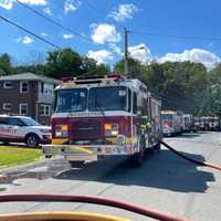 <p>Firefighters at the scene of a three-alarm fire at 2 Manor Drive, Groveland, on Friday afternoon.</p>