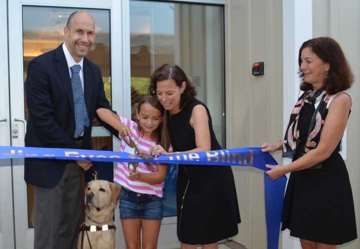 Guiding Eyes for the Blind President and CEO Thomas Panek with Gus the dog, assist in cutting the ribbon for the renovated Canine Development Center&#x27;s new puppy pavilion.