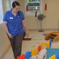 <p>Guiding Eyes for the Blind staff member Bethany Reinhardt gives a training demonstration in the Canine Development Center’s new puppy pavilion, an indoor socialization space where pups can work individually with staff and volunteers.</p>