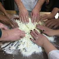 <p>Everyone with their hands in the dough</p>