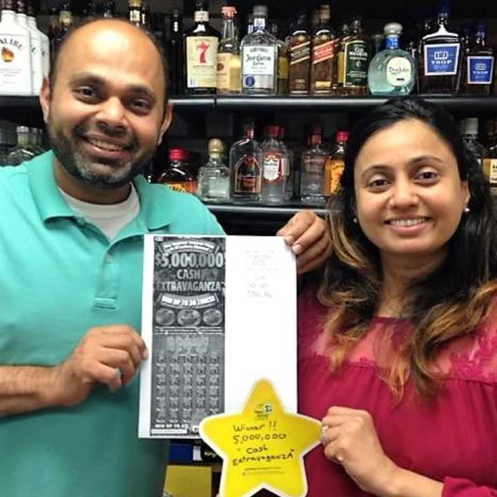 Krupen &quot;Kay&quot; Dudhia with his wife, Binal, and a copy of the winning ticket.