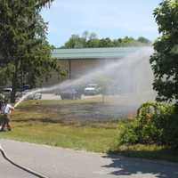 <p>Mahopac firefighters douse the flames of the brush fire.</p>