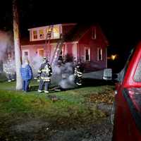 <p>Firefighters ladder the building to check the exterior and roof of the house.</p>