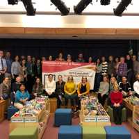 <p>Greenwich Public Schools staff surround a banner presented to the staff and students at the International School of Dundee. The district received the 2019 Connecticut Red Ribbon PASS Program Award for its physical education program.</p>