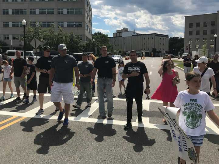 Dozens of people walked in Hackensack to support laid-off officers in June.