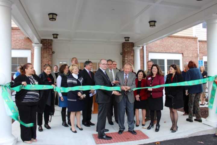 George Ciaccio cuts the ribbon to officially open Wilton Commons Congregate. Nick Lundgren, deputy commissioner of the state&#x27;s Dept. of Housing, is left of Ciaccio, and Renee Dobos, CEO of MHA, is to the right.