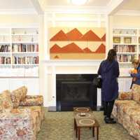 <p>Guests at the ribbon cutting ceremony for Wilton Commons Congregate look over the books shelved in the reception room.</p>