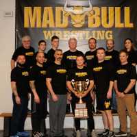 <p>Coaches for the Norwalk Mad Bulls show the championship trophy.</p>