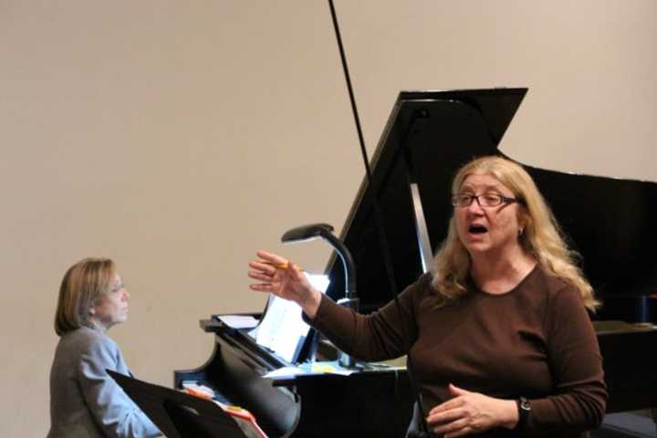 Christine Tenore accompanies Cantiamo Choir on piano as Marlane Tubridy conducts during a rehearsal for an upcoming concert.