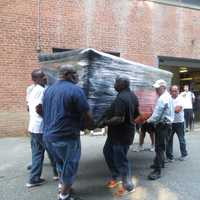 <p>Geddes Graham, a Lincoln Hall teacher and barber instructor; and James Coughlin, program director, were among those helping carry a Papal altar out of the Somers woodshop on Tuesday for use later this month by Pope Francis. </p>