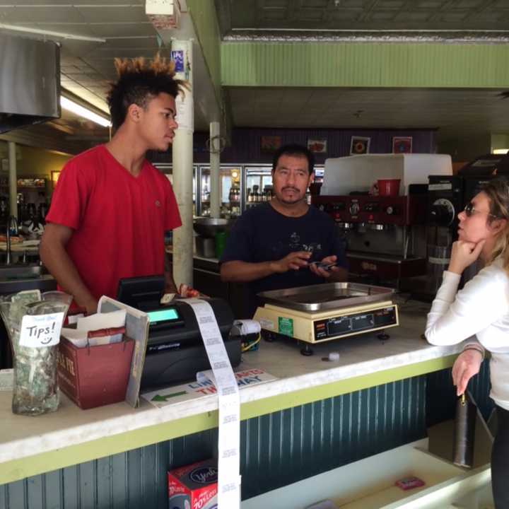 Harborview Market employees Thomas Cooper and Antonio Oaxaca talk about Tuesday election results with customer Candice Cole.