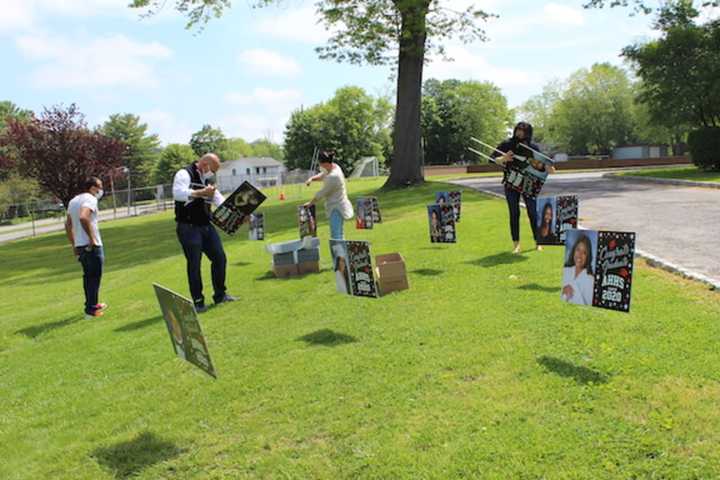 AHHS Principal Joseph Engelhardt, Superintendent Marc Baiocco, parent volunteer Lucie Rambaran and AHHS Assistant Principal Jessica Maracallo, assemble lawn signs to adorn the high school front lawn.