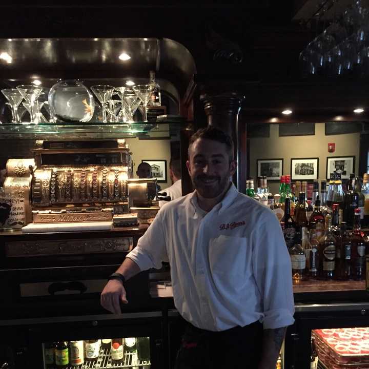 Bartender Will Secchi poses behind the bar. 