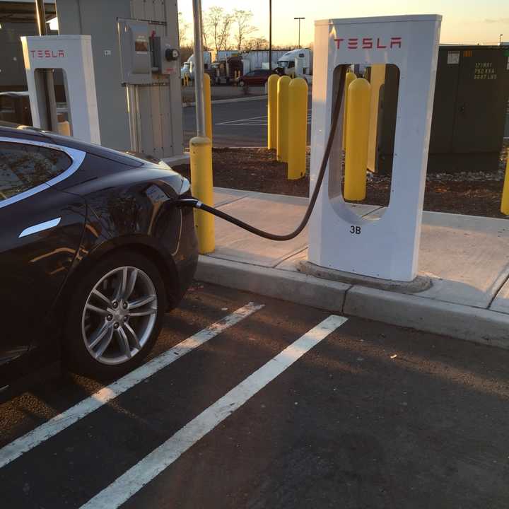 A Tesla charges up at an area station.