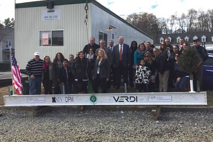 Representatives from the Connecticut Institute for Communities and Verdi Construction celebrate the final beam being hoisted into place at the future site of the Greater Danbury Community Health Center.