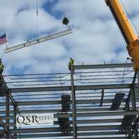 <p>The final beam of the Greater Danbury Community Health Center, adorned in an American flag and a Christmas tree, is put into place at the top of the building.</p>