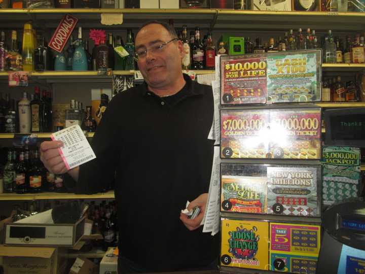 Lewis Stern holds up a Powerball ticket at Yorktown Wine and Liquors.